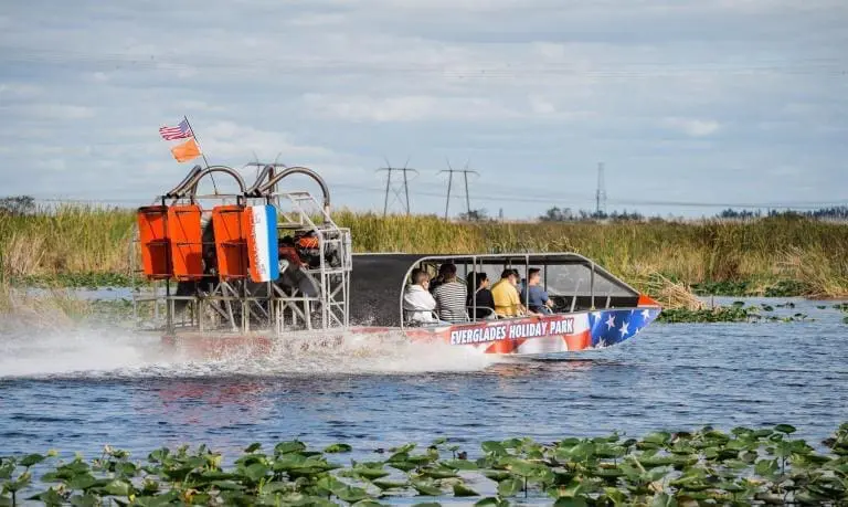 Everglades boat tour - swamp boat going fast with everglades boat tour passengers